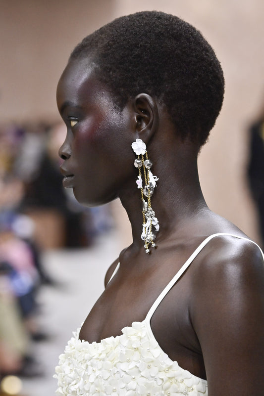 A runway model wears long cascading statement earrings at Paris Fashion Week in October 2026
